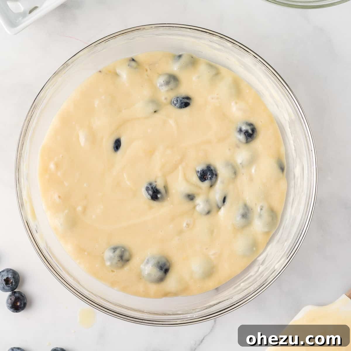 Finished cake mix muffin batter with fresh blueberries evenly mixed in, showcasing its ready-to-bake consistency