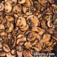 Teriyaki mushrooms in a bowl, garnished with green onions and sesame seeds.