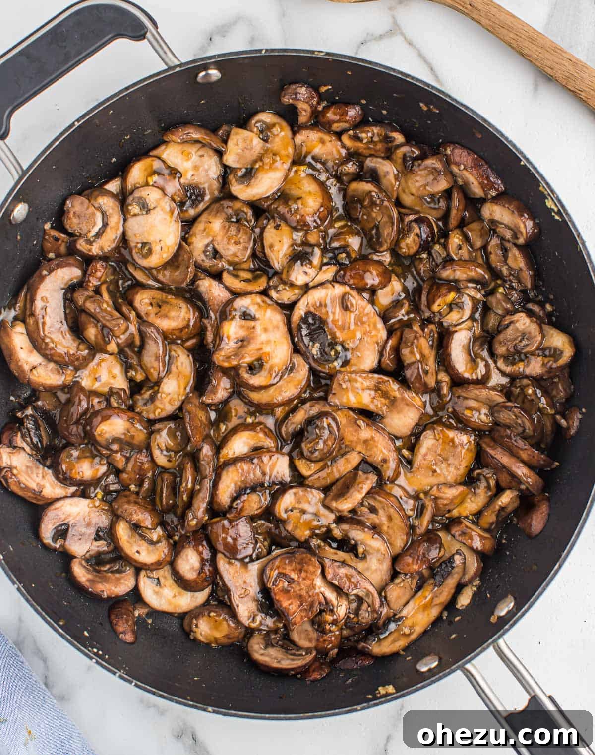 Teriyaki-glazed mushrooms sizzling and caramelizing in a large skillet, showcasing their rich color and inviting texture.