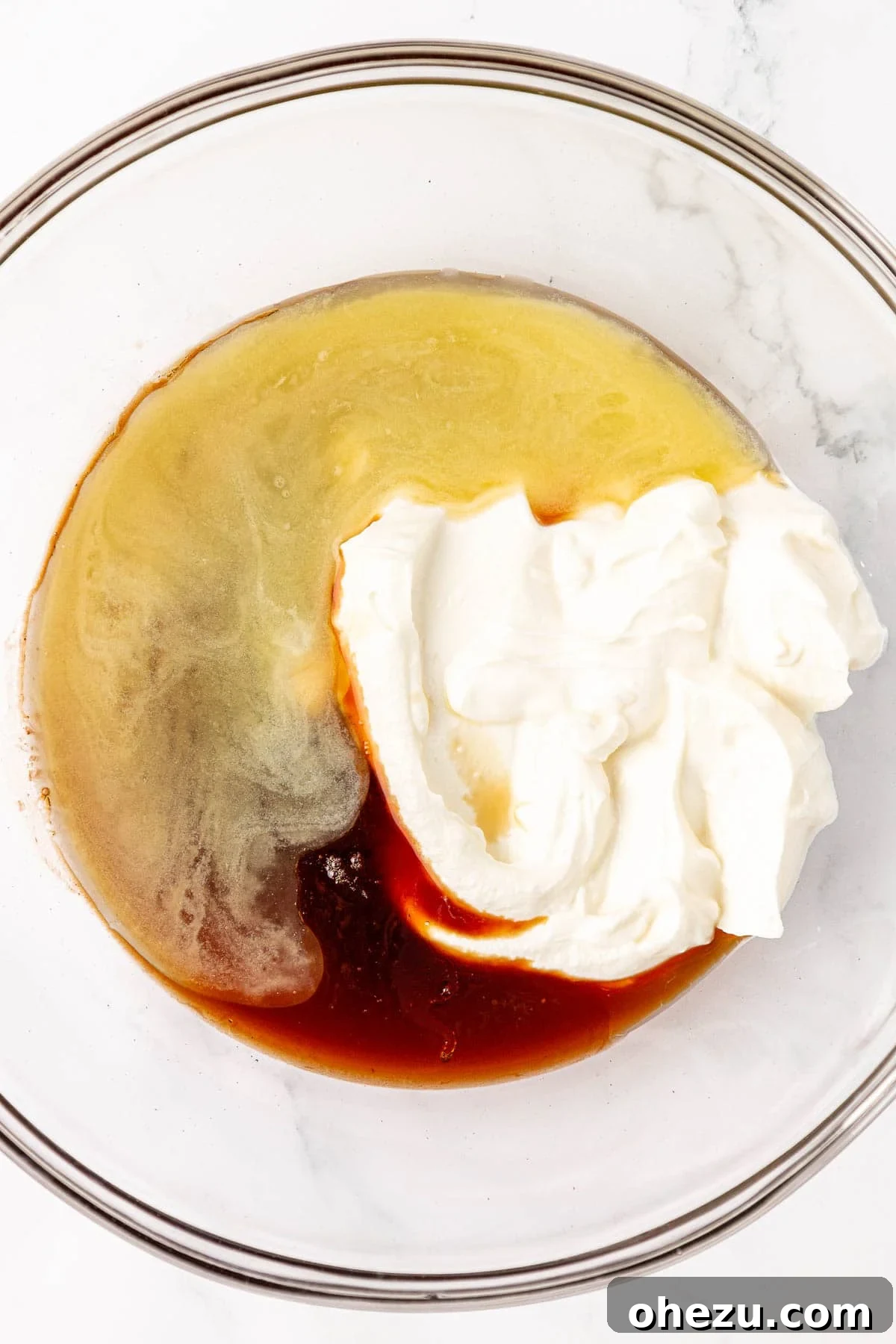 All wet ingredients, including Greek yogurt and maple syrup, in a mixing bowl.
