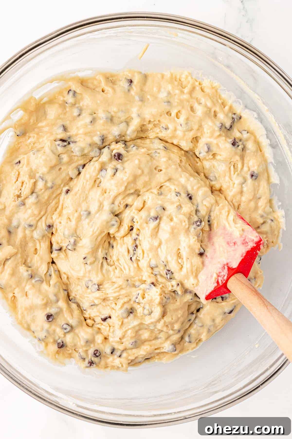 Mini chocolate chips gently folded into the muffin batter with a rubber spatula.