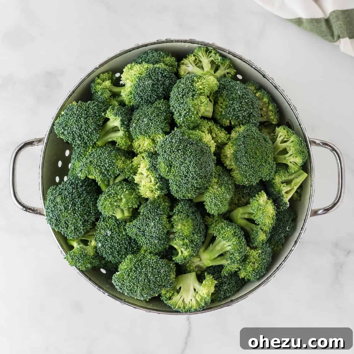 Crispy Parmesan Roasted Broccoli 4 Fresh broccoli florets draining in a colander after being washed, ready to be patted dry