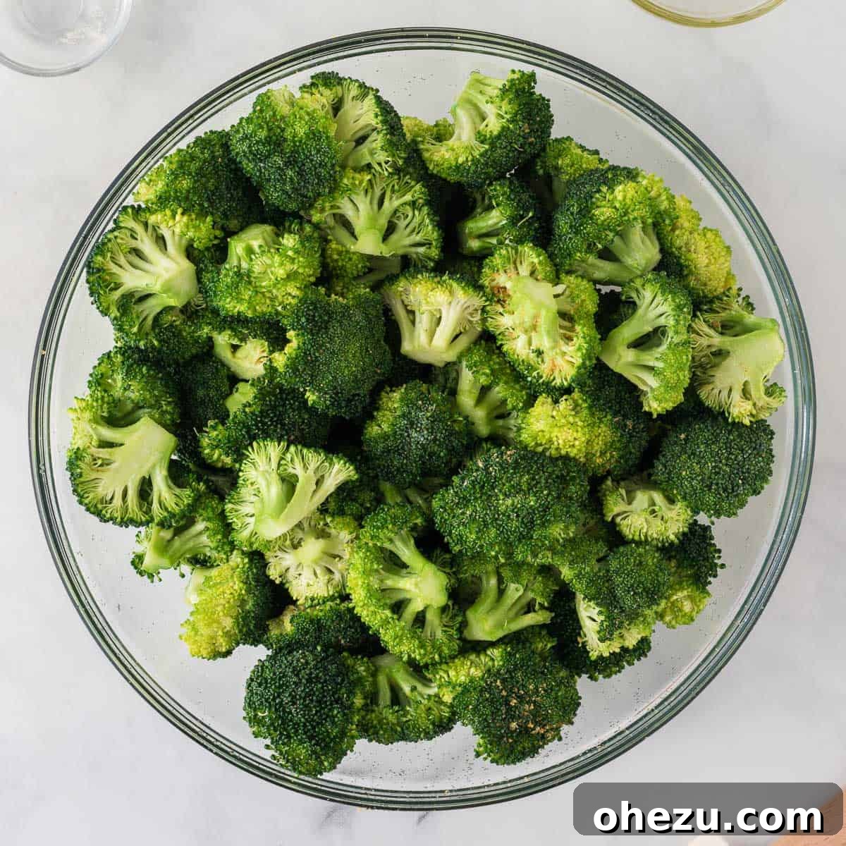 Crispy Parmesan Roasted Broccoli 7 Broccoli florets perfectly mixed with olive oil and spices, spread in a single layer on a baking pan, ready for the oven