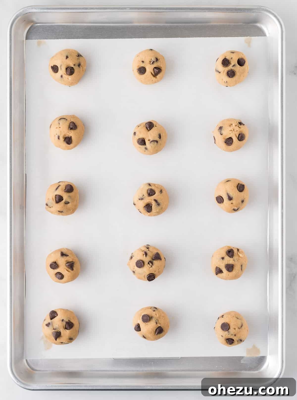 Decadent Dairy-Free Chocolate Chip Cookies 12 Balls of dairy-free cookie dough on a baking sheet