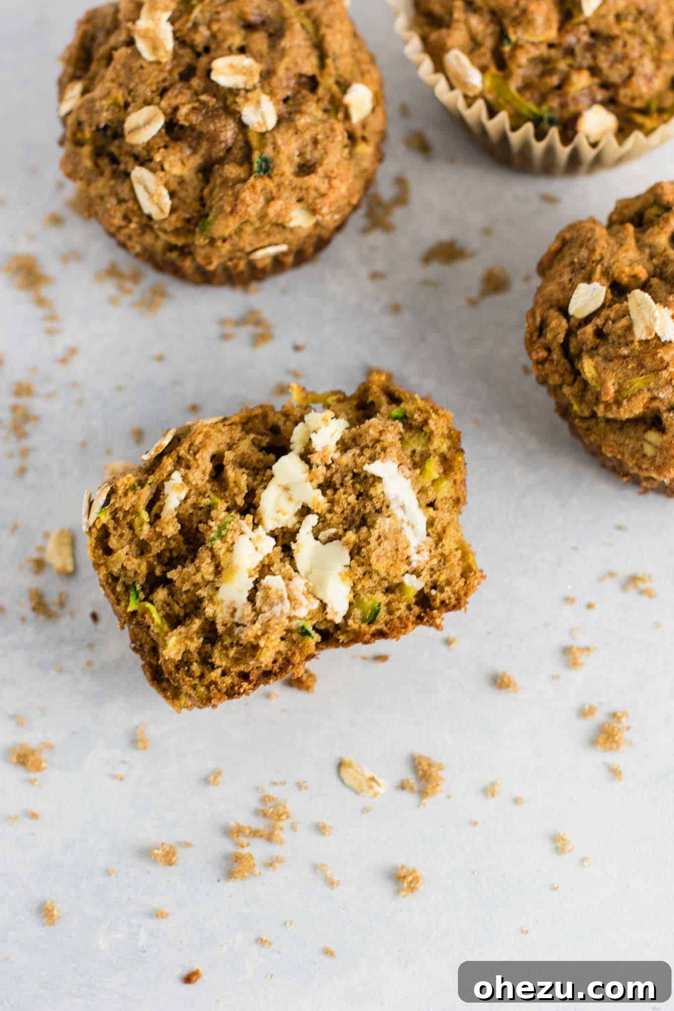 A healthy zucchini bread muffin split in half, revealing its tender crumb and inviting texture.