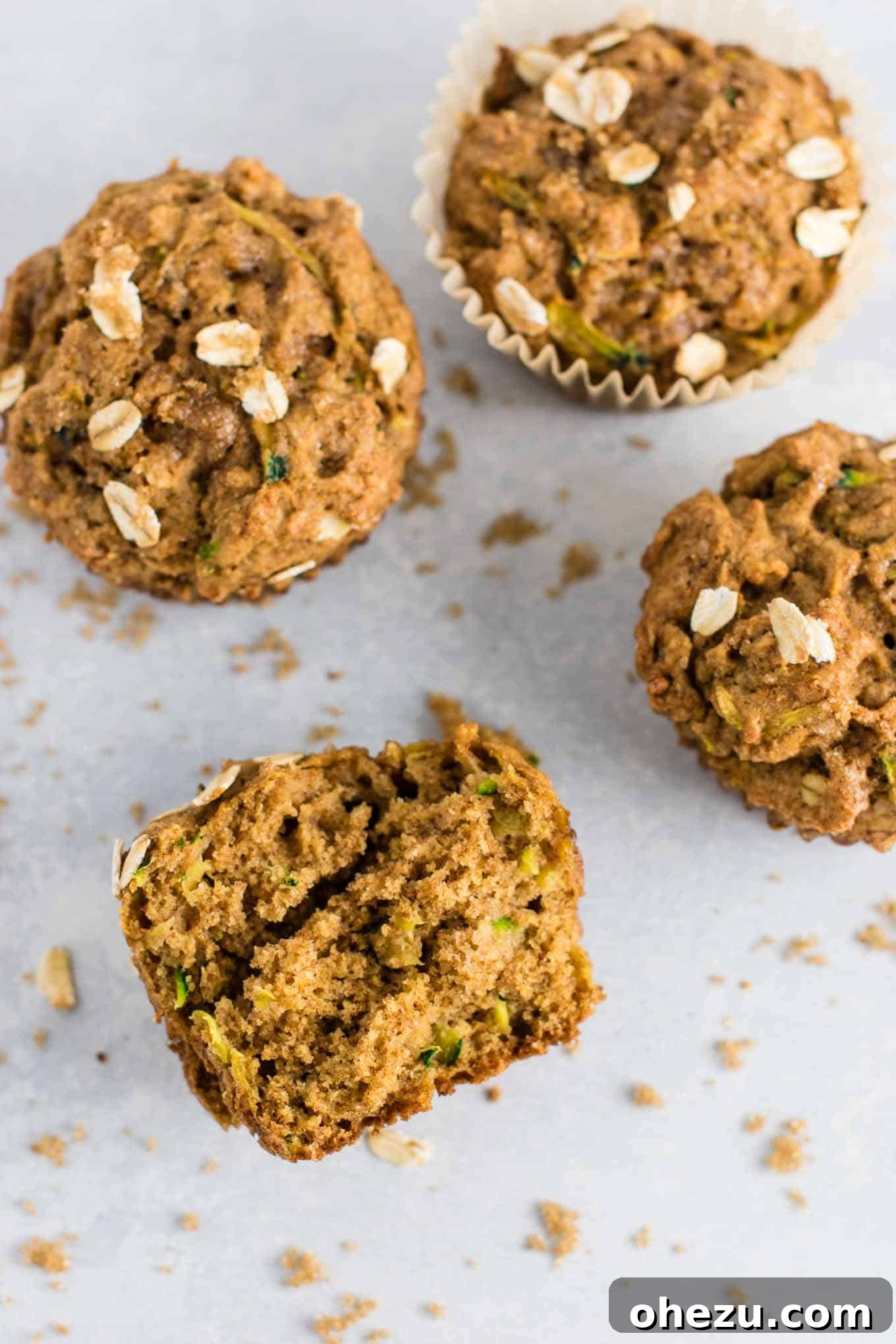 A close-up of a zucchini bread muffin, highlighting the rustic oat topping.