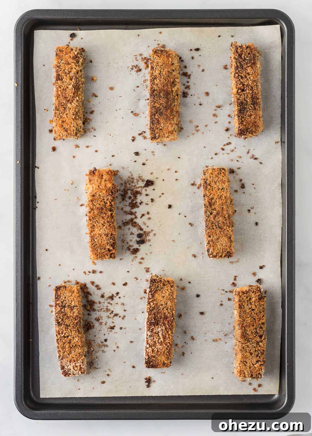 Vibrant Tofu Wraps 13 Golden-brown, crispy baked tofu slices artfully arranged on a baking sheet, fresh out of the oven.