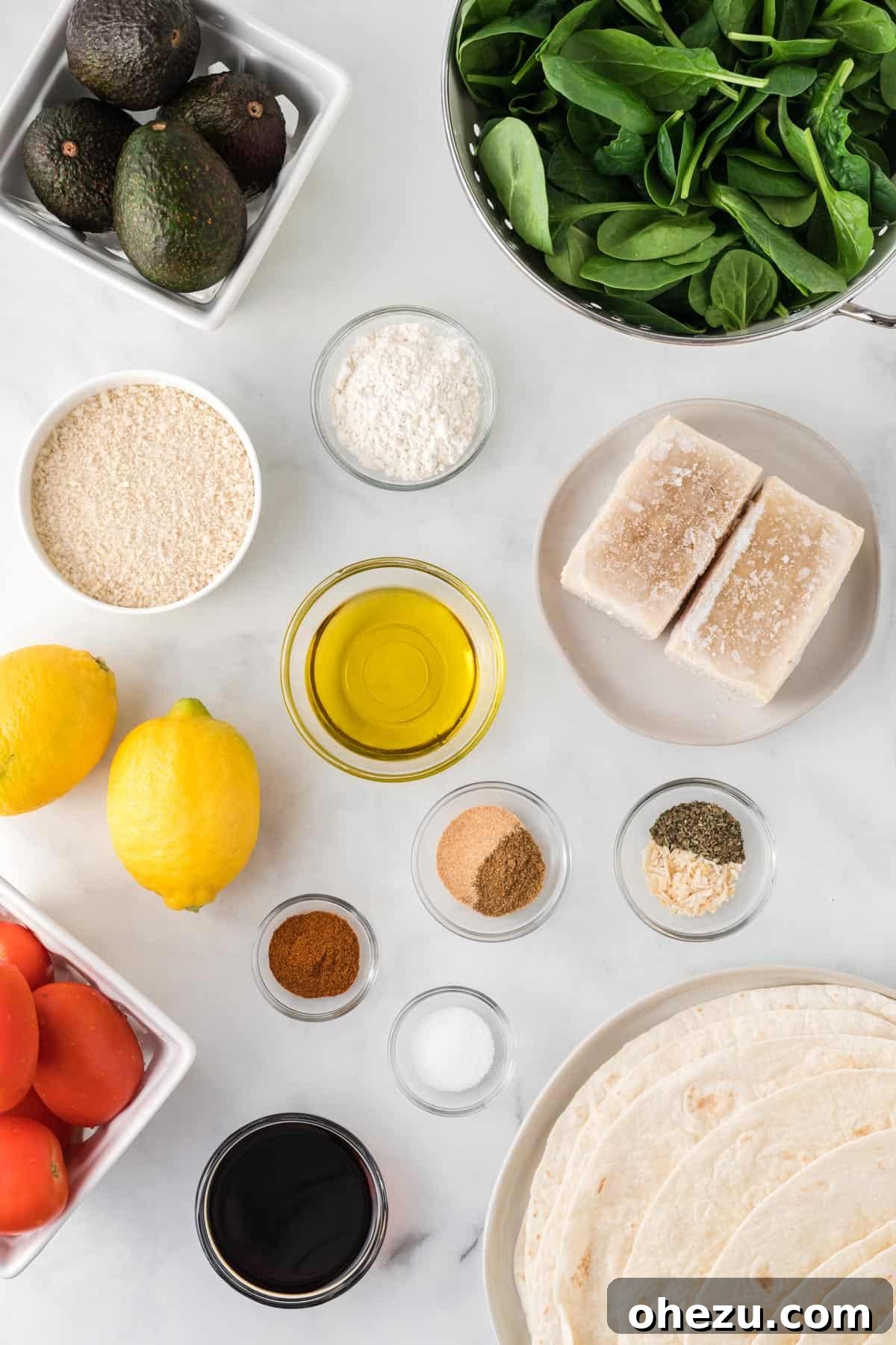 Vibrant Tofu Wraps 4 A vibrant flat lay showcasing all the fresh ingredients needed to make crispy tofu wraps: tofu, various spices, soy sauce, olive oil, tortillas, avocado, lemon, tomatoes, and spinach.