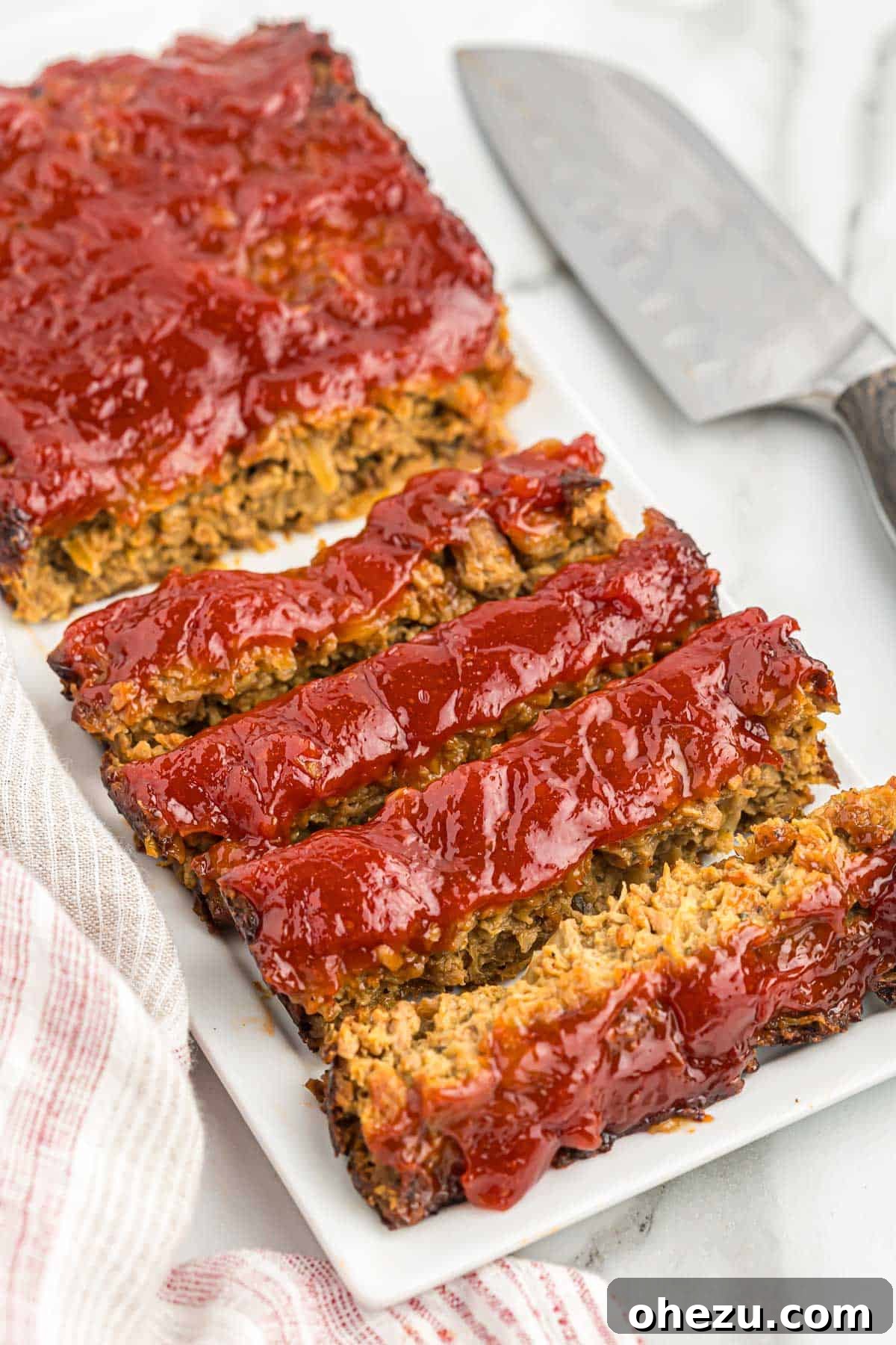 Meatless Meatloaf Marvel 16 Beautifully cut slices of vegetarian meatloaf arranged on a serving platter, highlighting its uniform texture and the delicious glaze, ready for sharing.