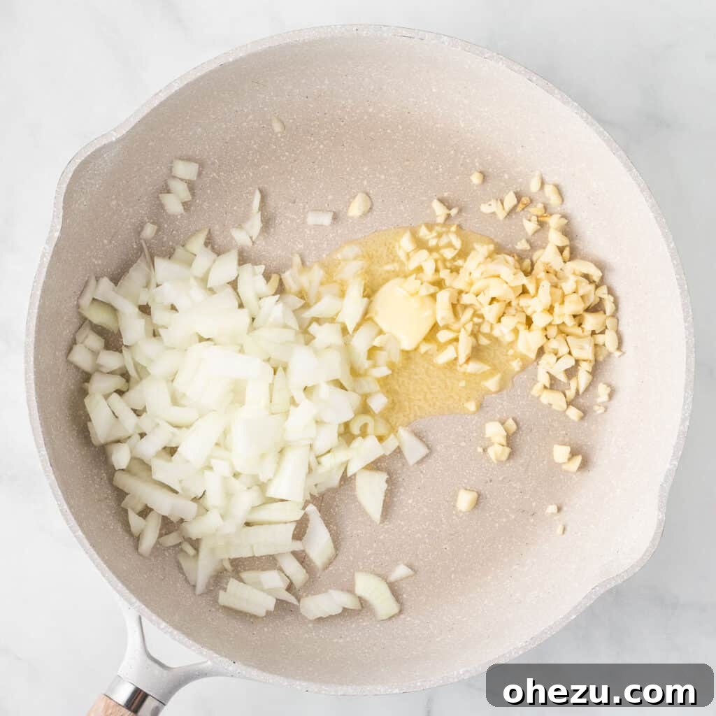 Meatless Meatloaf Marvel 6 Freshly minced garlic and diced onion sizzling gently in melted butter within a skillet, releasing their sweet aromas as they soften for the meatloaf base.