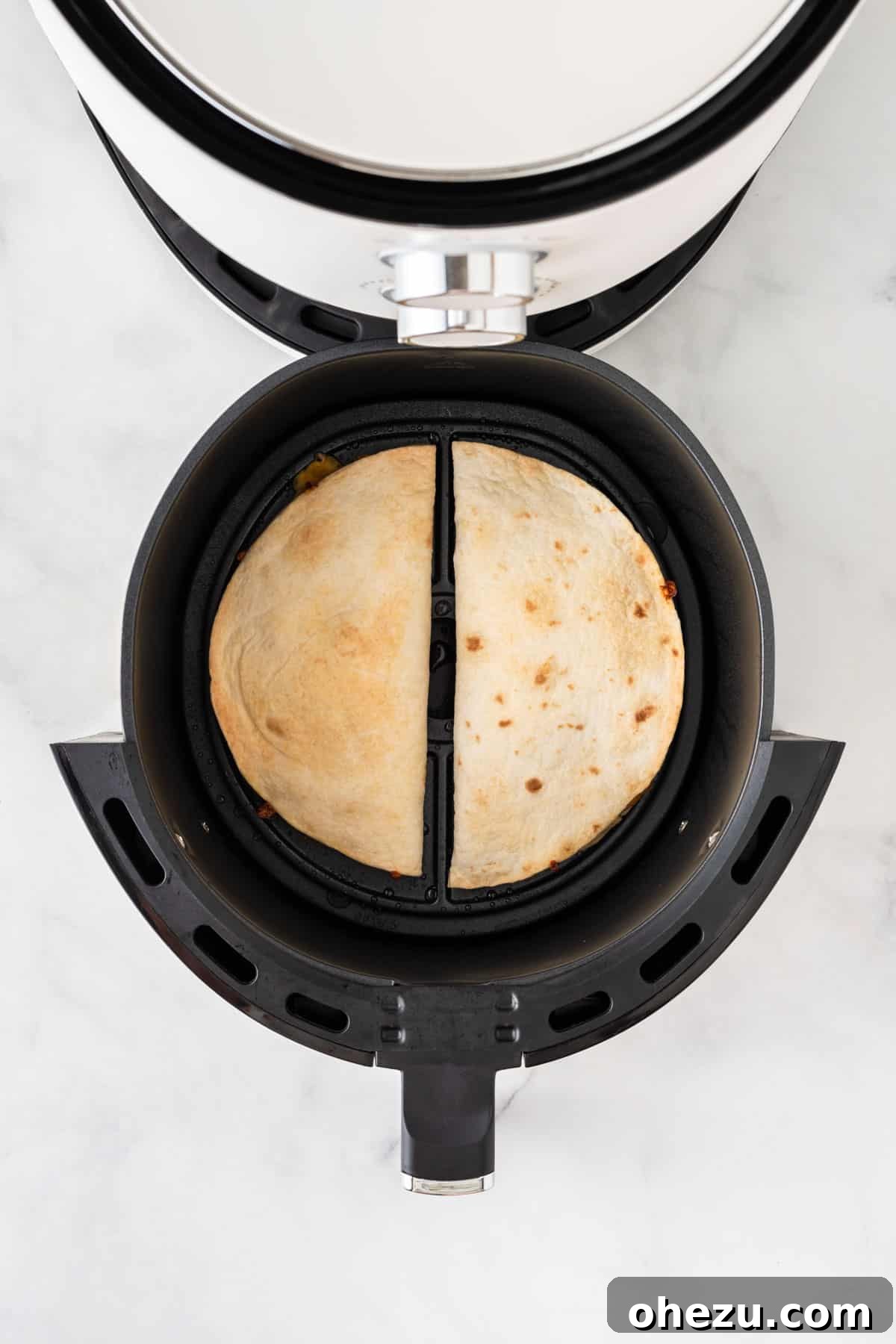 Crispy, golden-brown quesadillas visible inside the air fryer basket, indicating they are perfectly cooked.