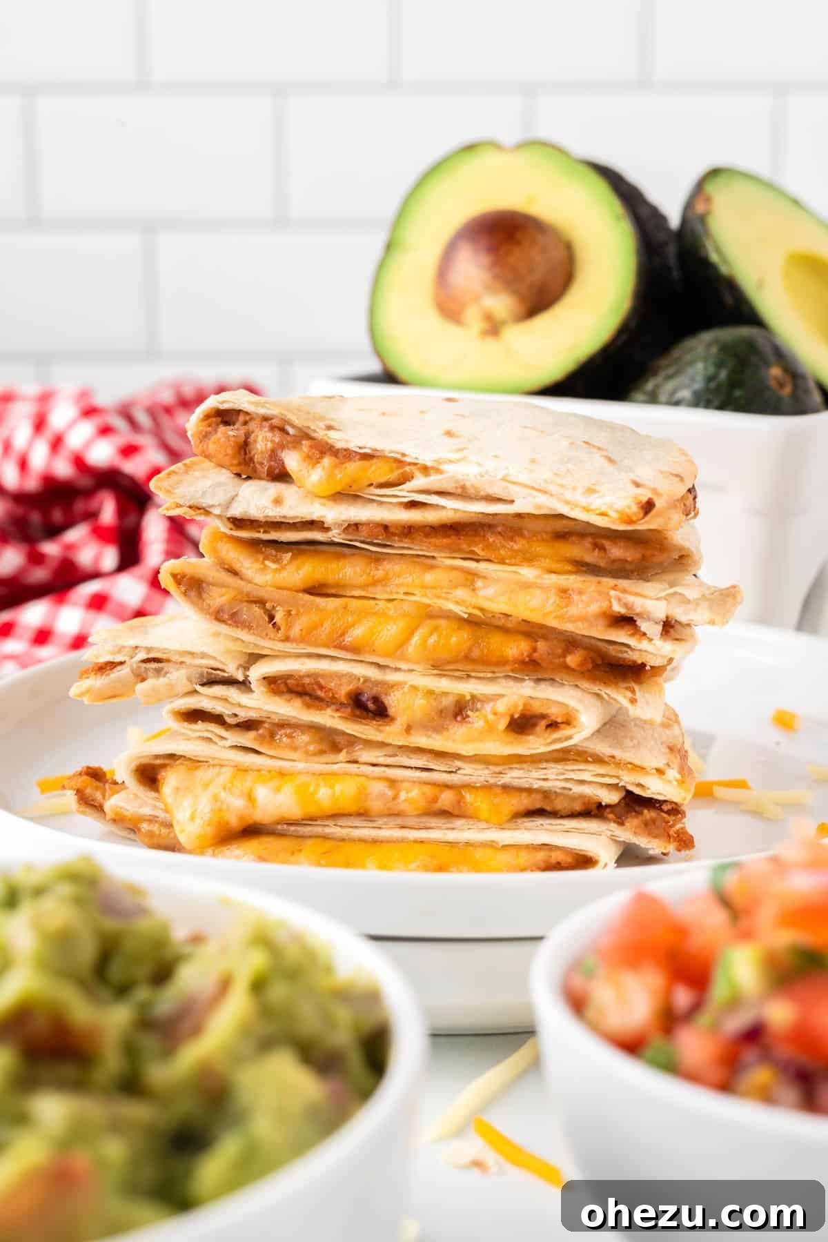 A stack of golden-brown, crispy air fryer quesadillas presented on a white plate, highlighting their perfect texture.