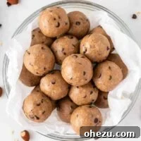 A close-up of a neatly stacked pile of almond butter protein balls, showcasing their appealing golden-brown color and round shape.