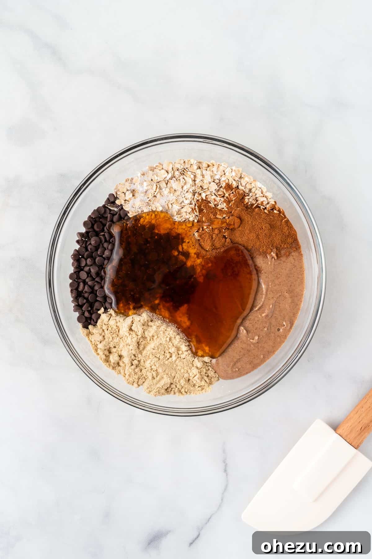 Wholesome Almond Butter Protein Bites 5 All the almond butter energy ball ingredients mixed together in a large glass bowl, forming a thick, uniform batter, ready for the next step.