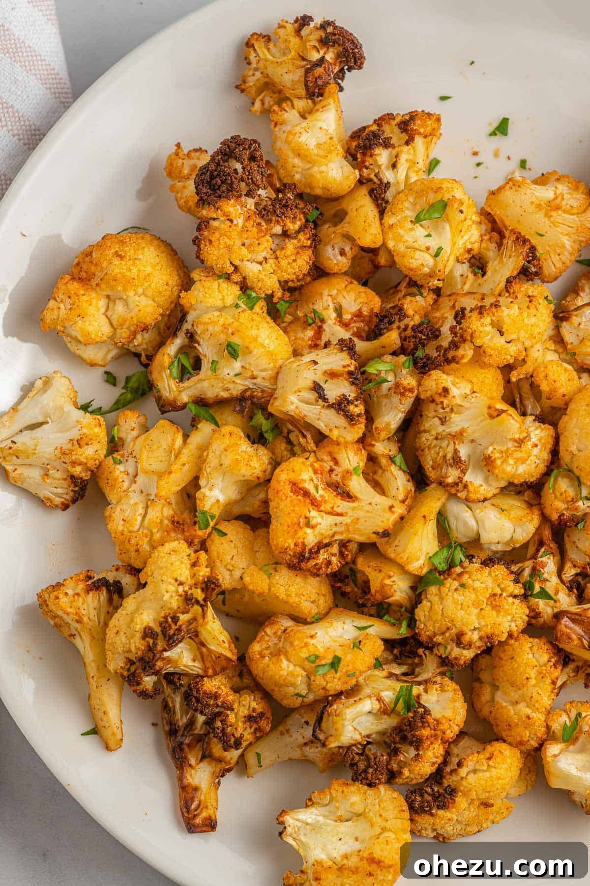 Perfectly roasted cauliflower florets served on a plate, showcasing their golden-brown crispiness.