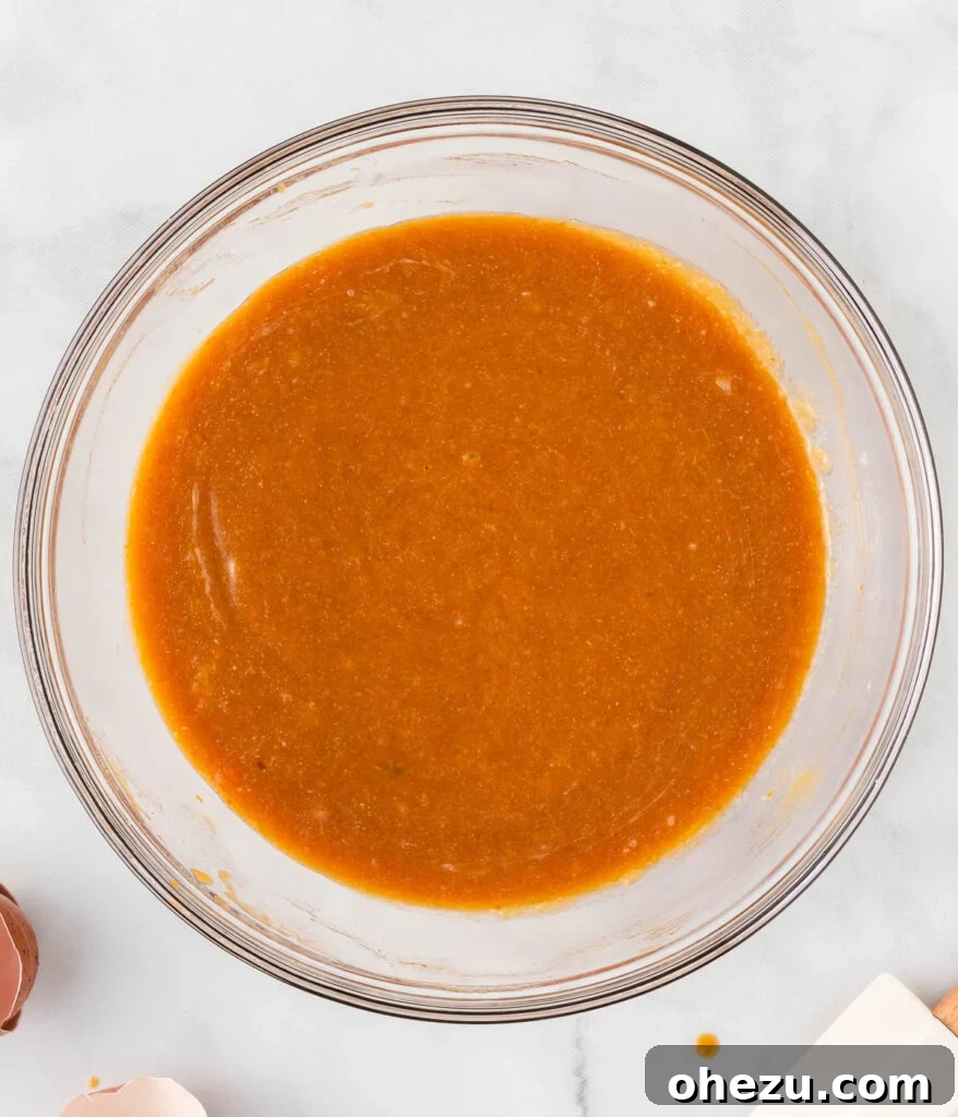 A perfectly blended mixture of wet ingredients, smooth and rich in color, in a mixing bowl.