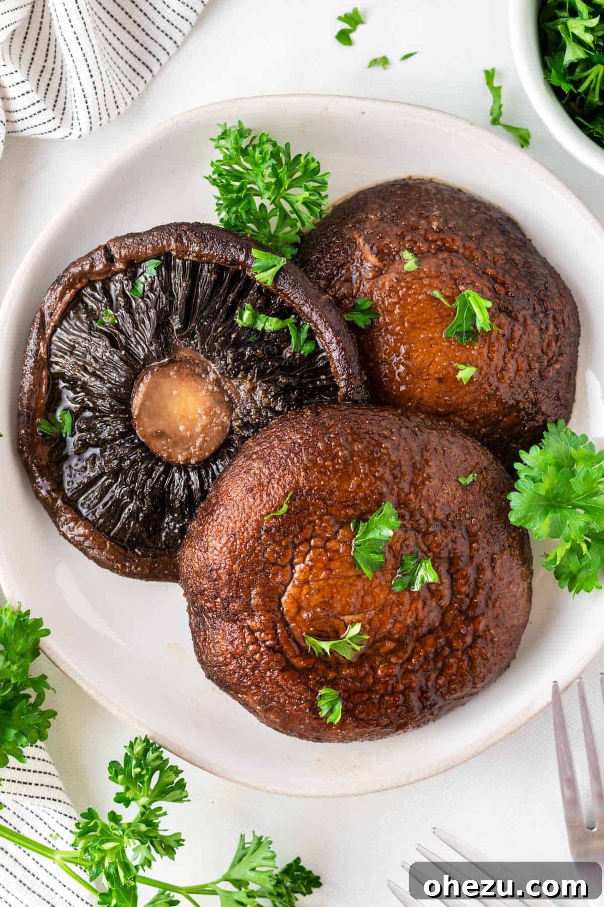 Perfect Air Fryer Portobello 2 portobello mushrooms topped with parsley on a plate