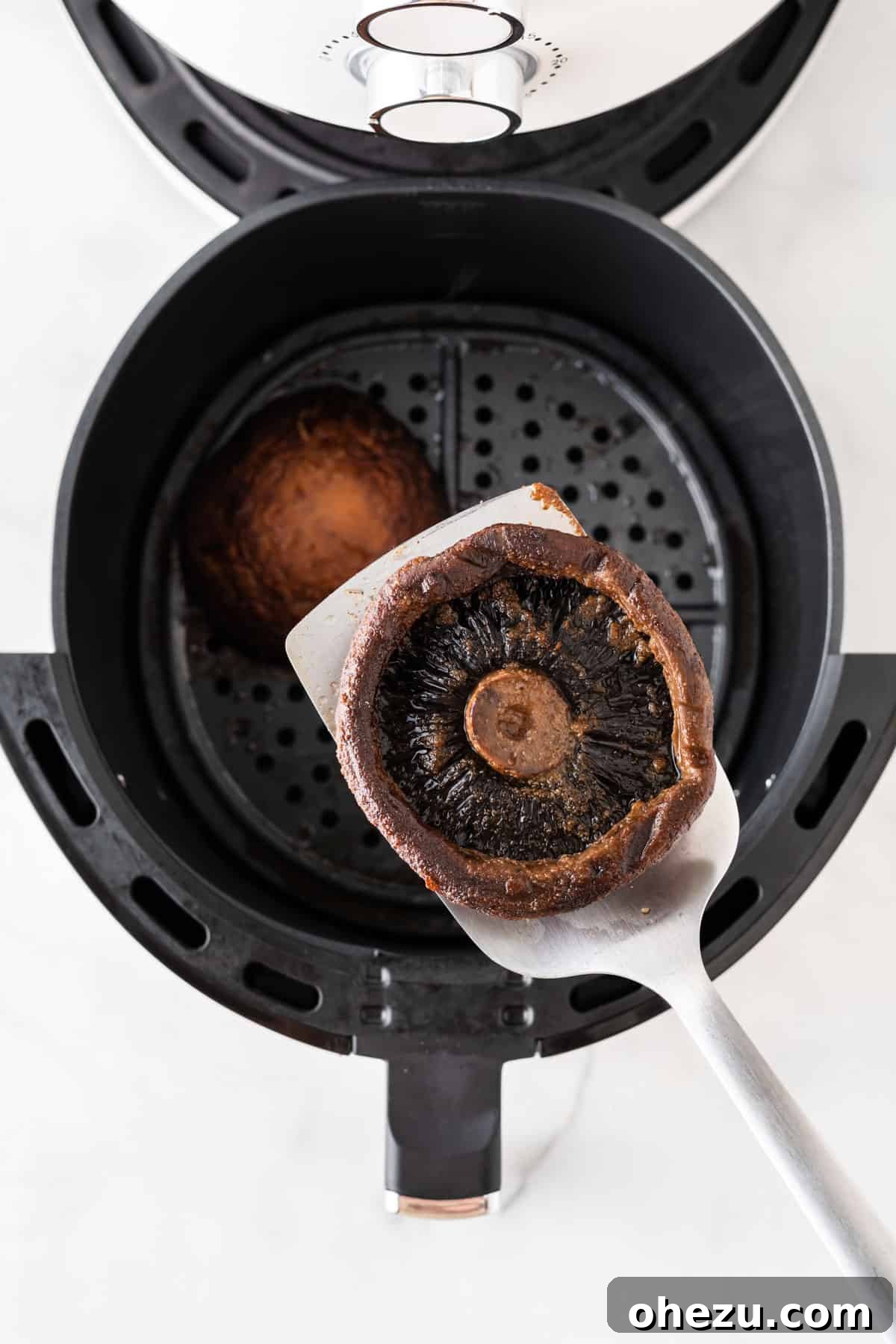 Perfect Air Fryer Portobello 8 taking a mushroom from the air fryer