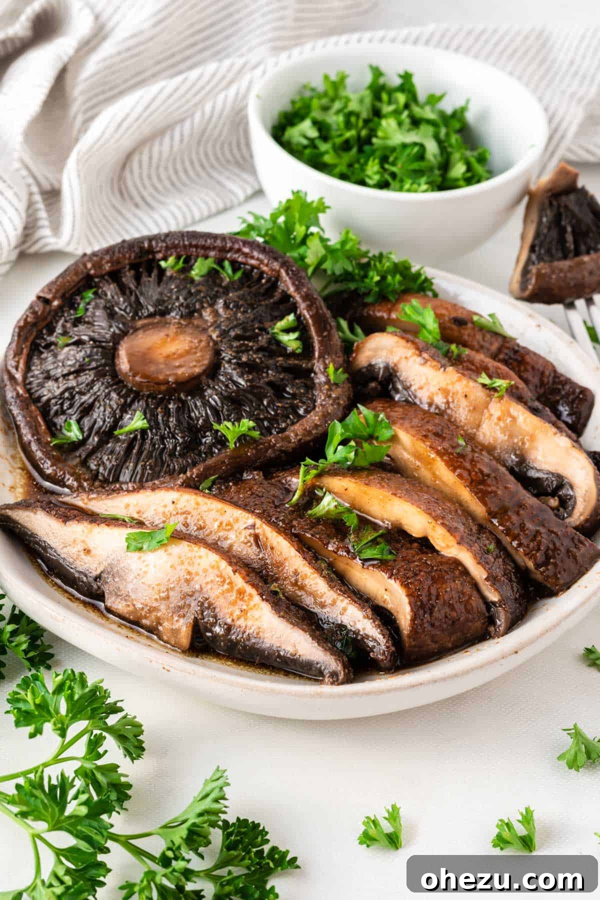 Perfect Air Fryer Portobello 9 portobello mushrooms cut into slices topped with parsley on a plate