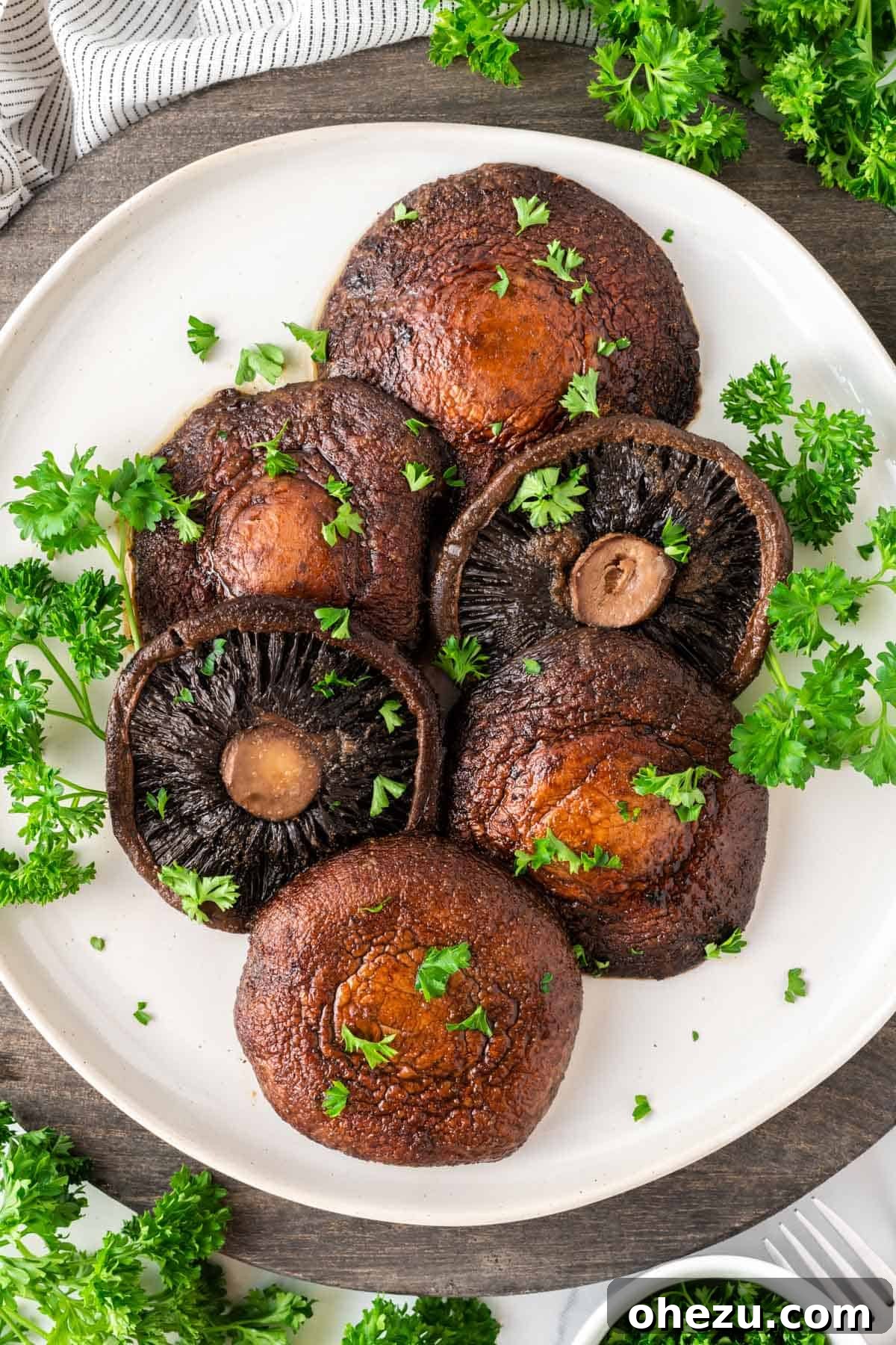 Perfect Air Fryer Portobello 10 portobello mushrooms topped with parsley on a plate