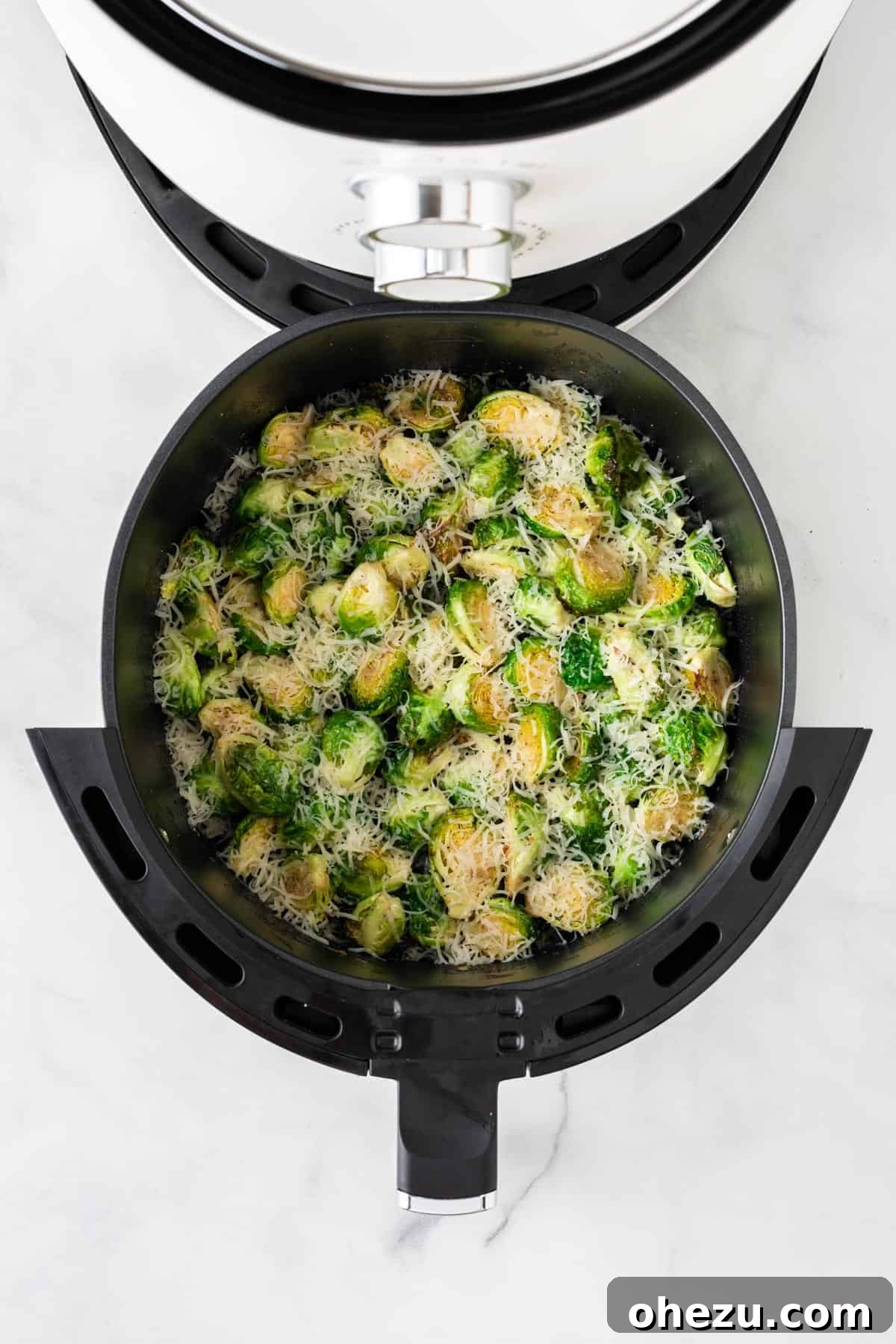Perfectly Crispy Air Fryer Brussels Sprouts 9 Sprinkling fresh Parmesan cheese over air-fried Brussels sprouts