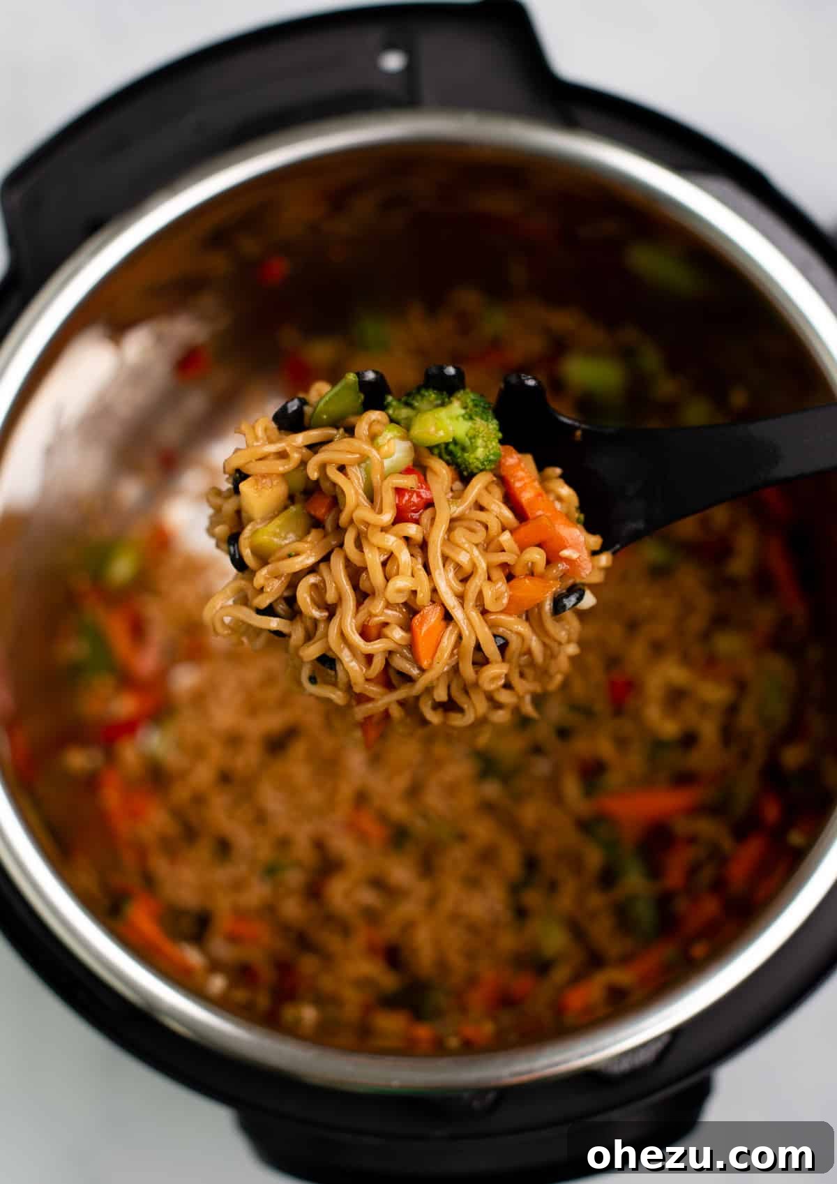 Instant Pot stir fry scooped into a bowl, topped with sweet chili sauce and fresh green onions