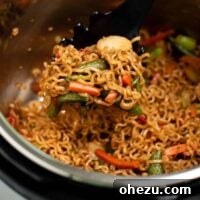 Taking a scoop of stir fry noodles from the instant pot, highlighting the ease of serving