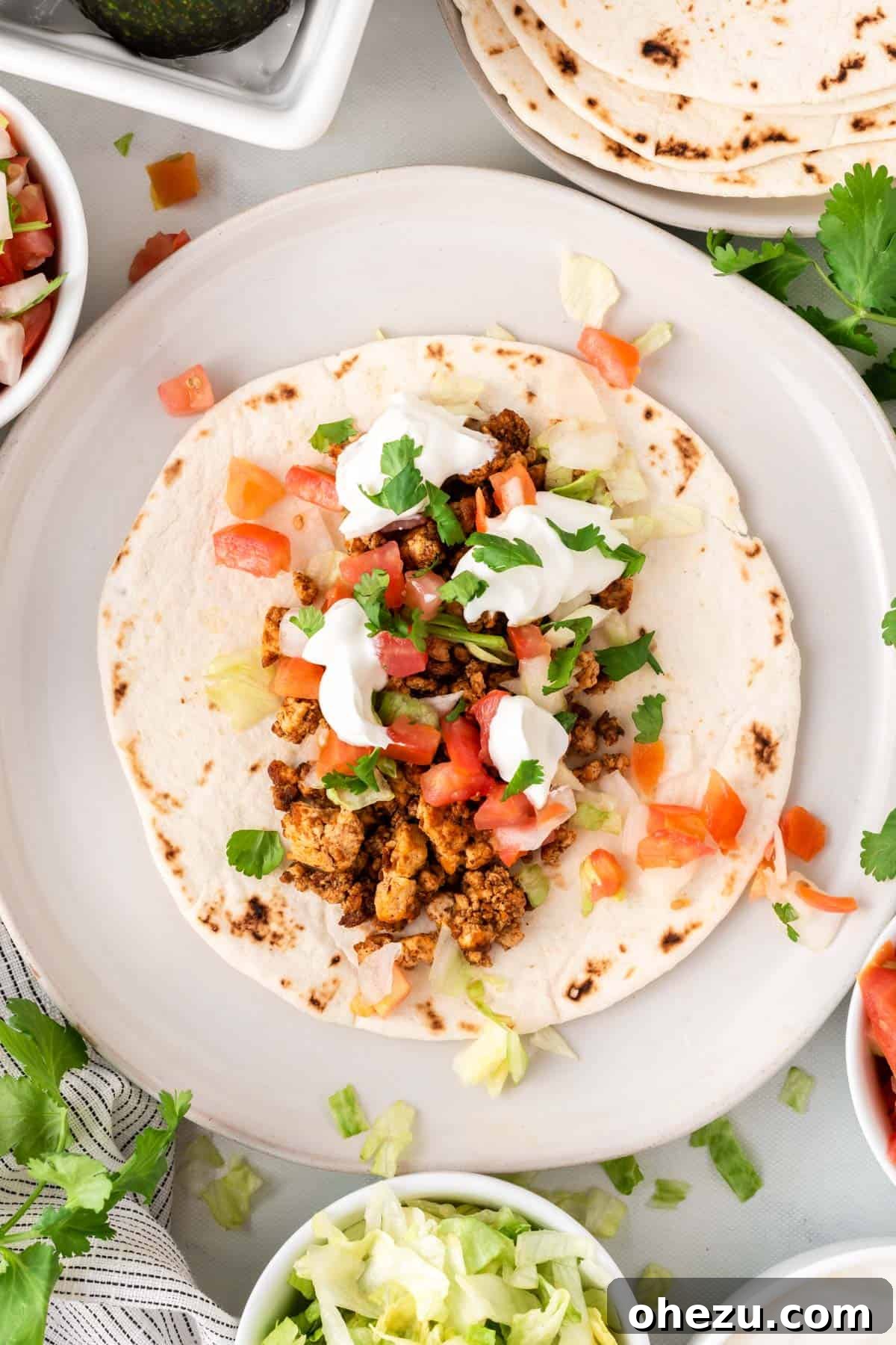 tofu taco topped with sour cream, cilantro, and tomatoes