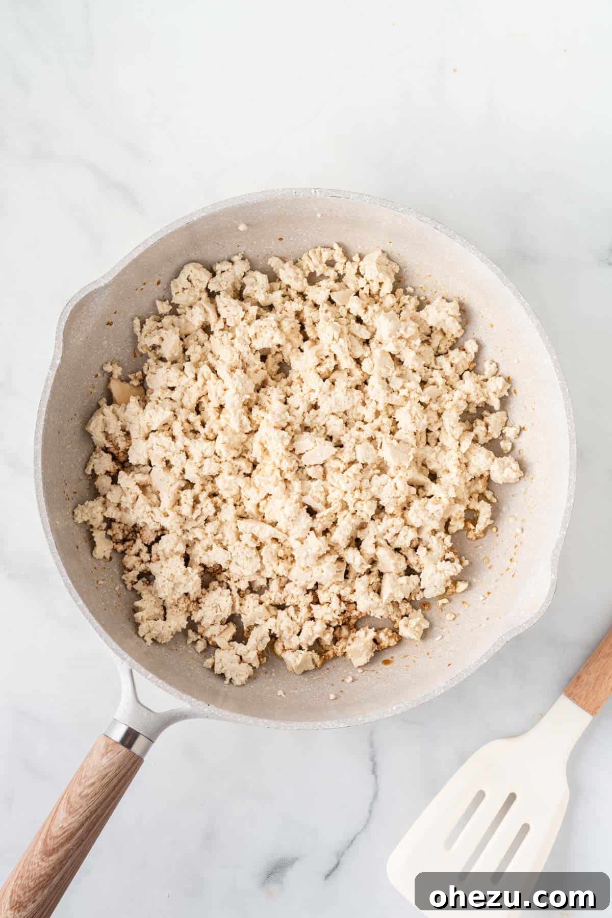 adding the crumbled tofu to the skillet