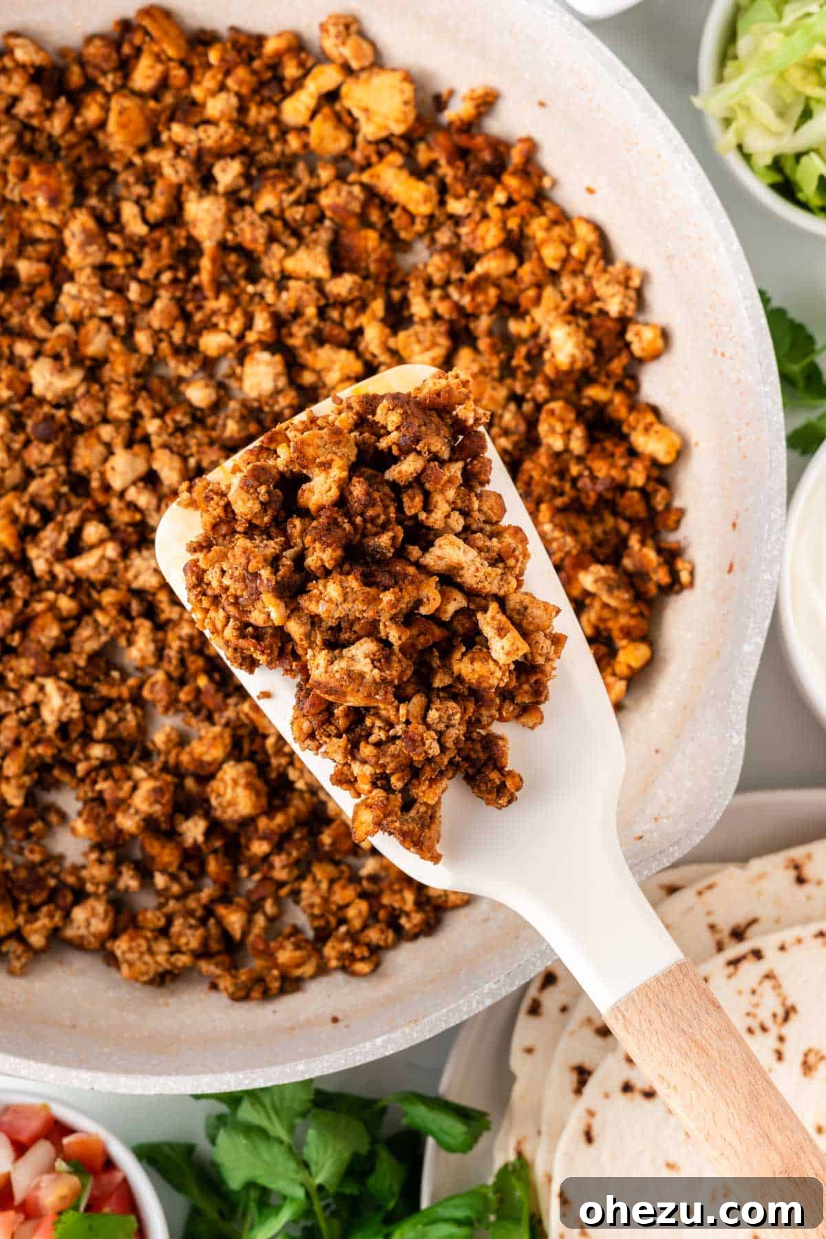 spatula taking tofu taco crumbles from the pan