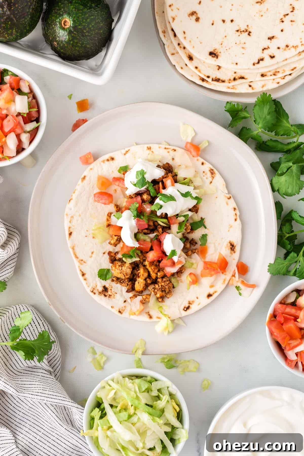 tofu taco topped with sour cream, cilantro, and tomatoes