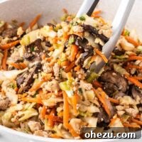 tongs taking egg roll filling from the skillet