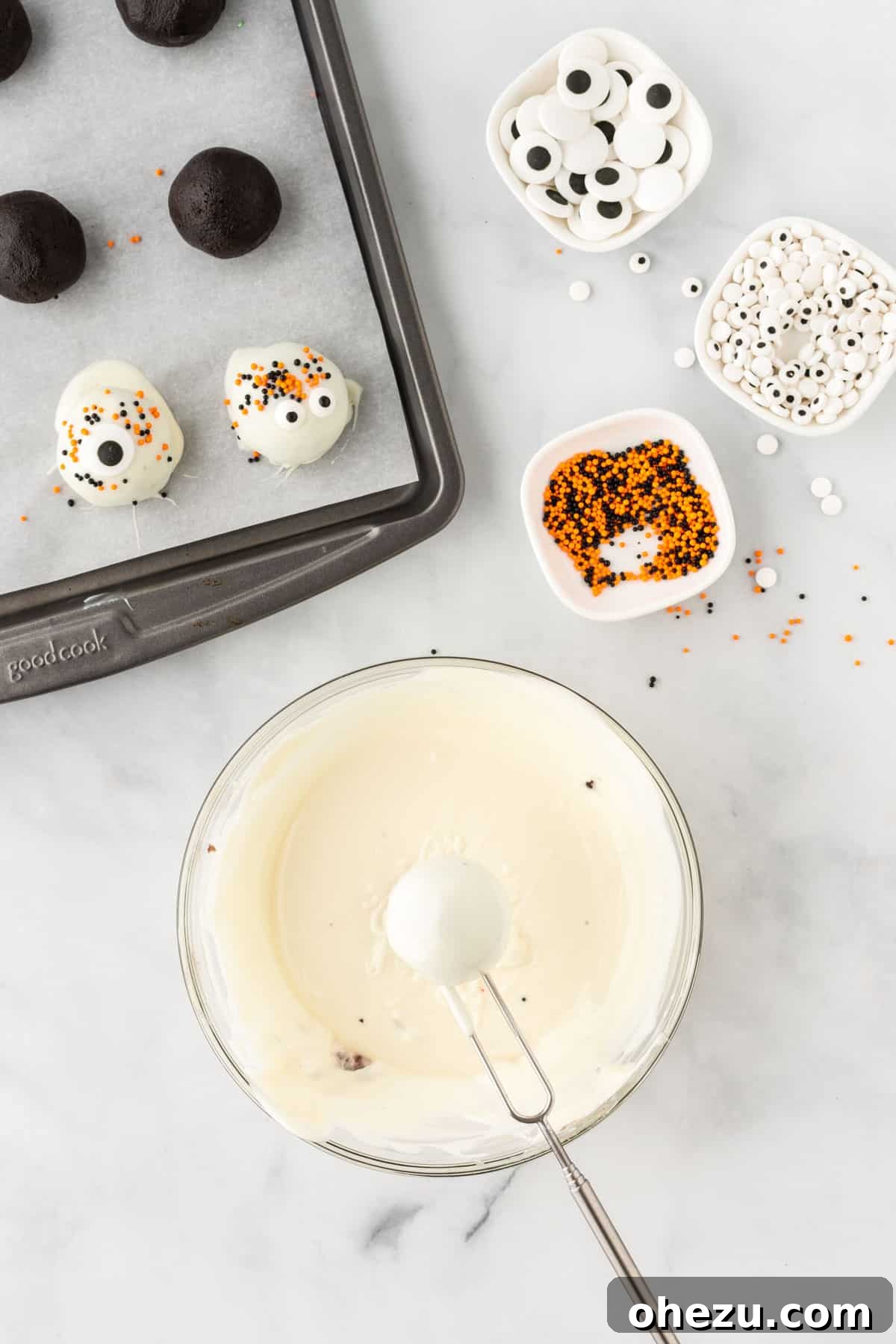 Wicked Oreo Truffles 13 An Oreo ball being dipped into melted white chocolate, showing a smooth coating