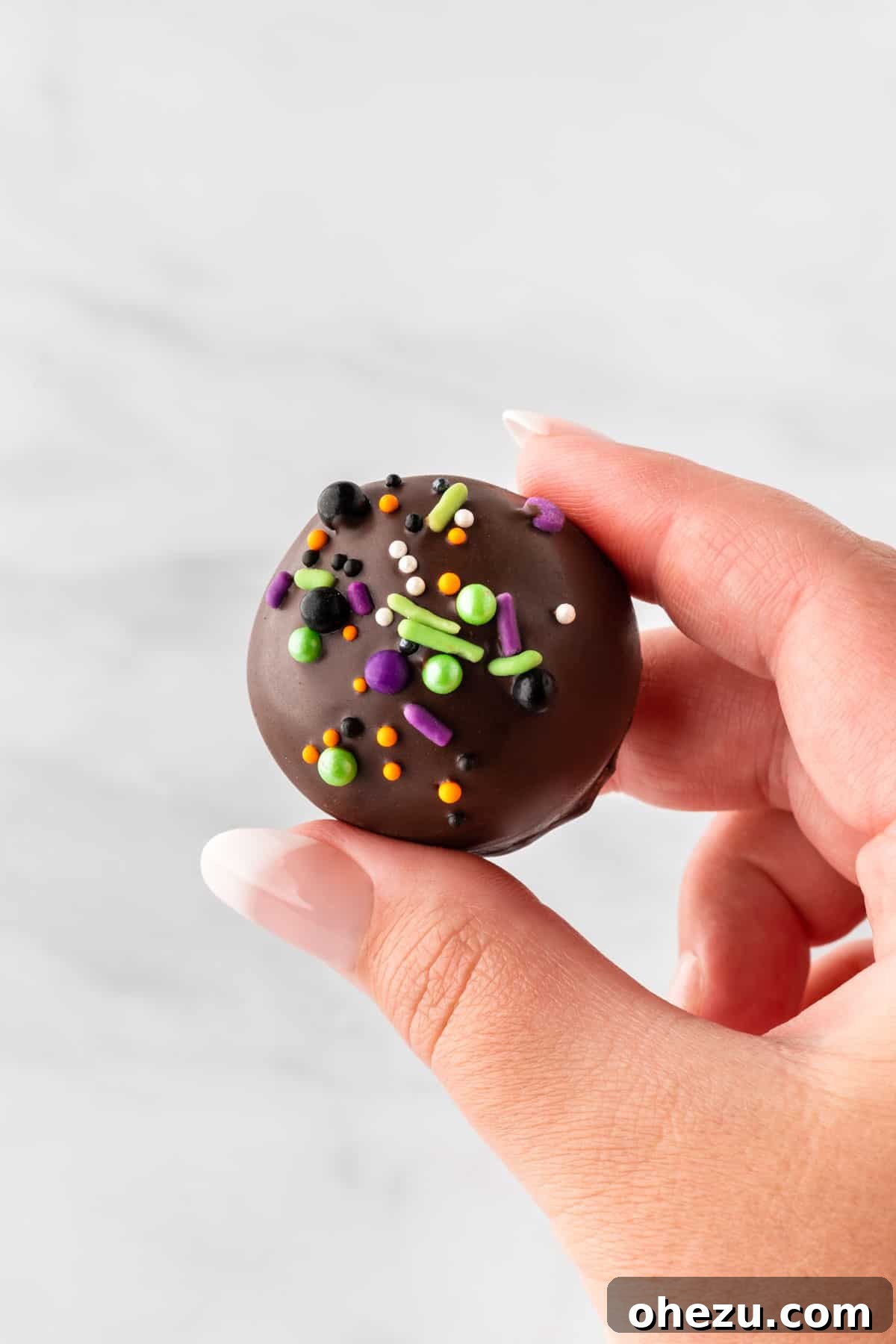Wicked Oreo Truffles 19 Another view of a hand holding an Oreo ball, highlighting the festive decorations