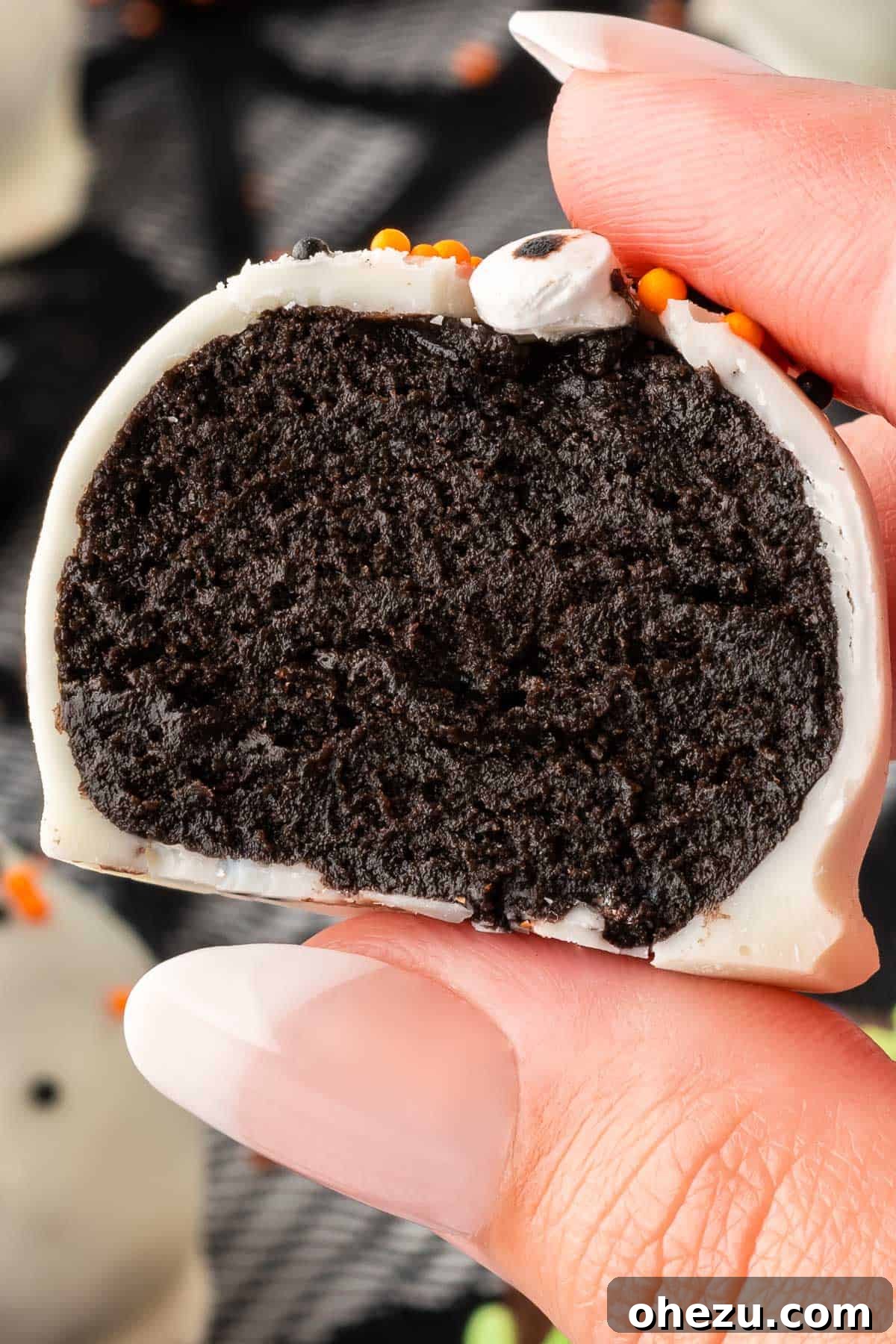 Wicked Oreo Truffles 21 An Oreo ball cut open, revealing the dark, fudgy interior of crushed Oreos and cream cheese
