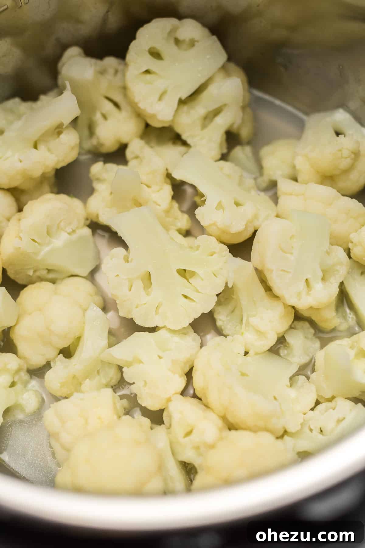 Perfectly steamed cauliflower florets in a serving bowl, ready to eat.