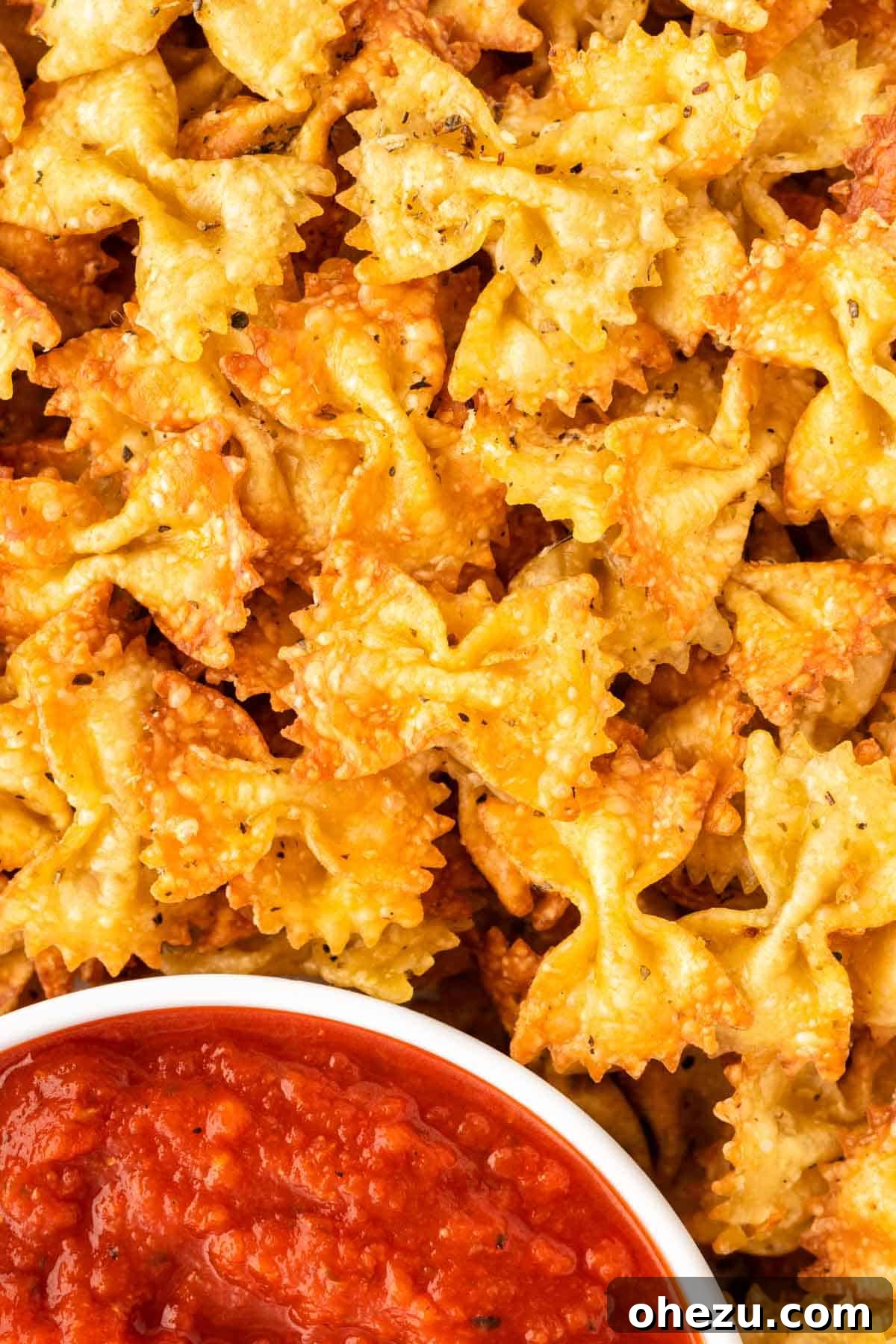 Air fryer pasta chips beautifully arranged next to a bowl of marinara dip