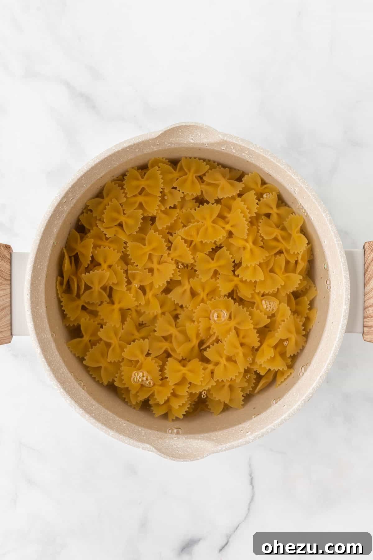 Bowtie pasta cooking in a saucepan on the stove