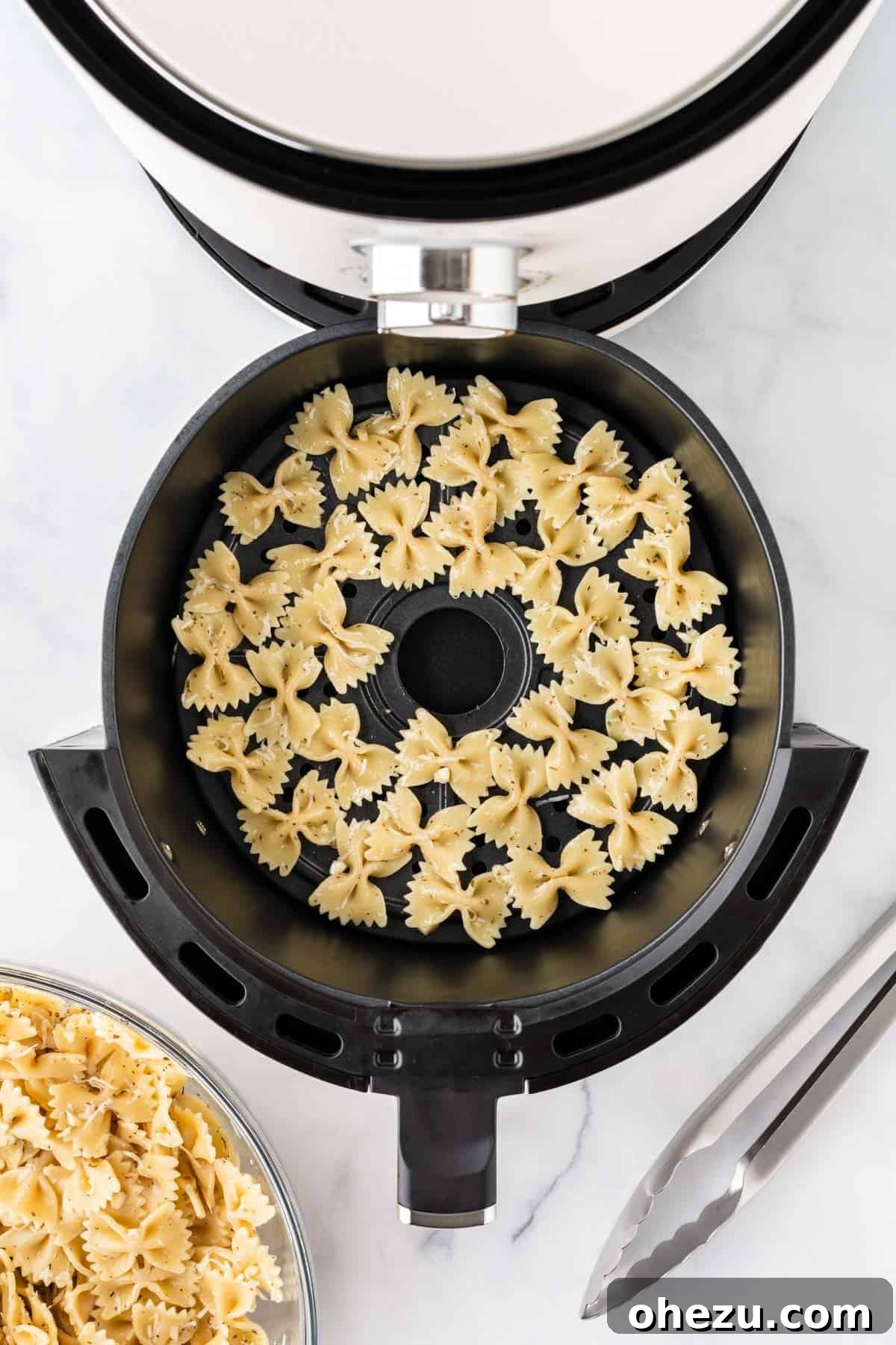 Bowtie pasta arranged in a single layer in the air fryer basket