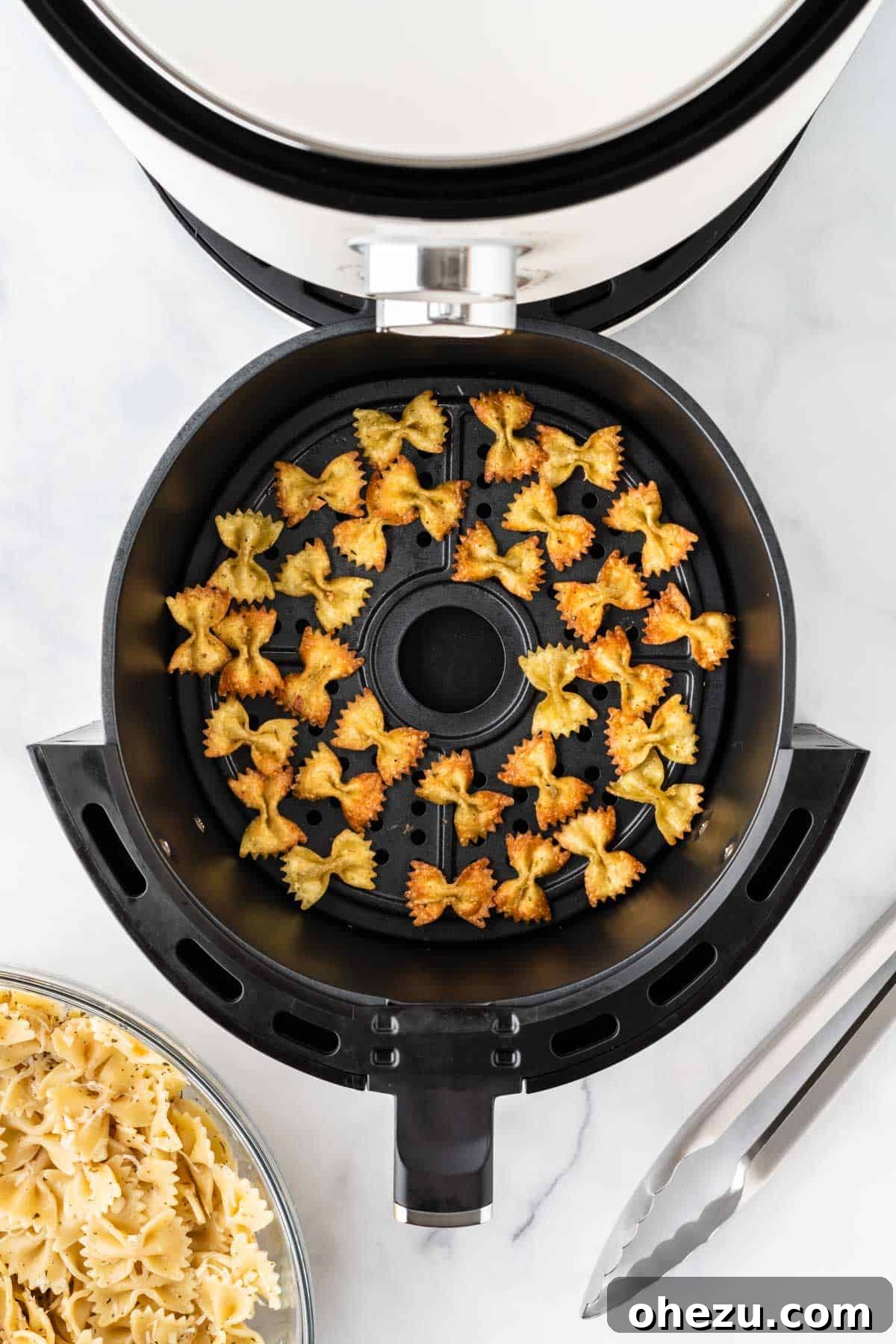 Air fryer pasta chips cooking in the basket, beginning to crisp