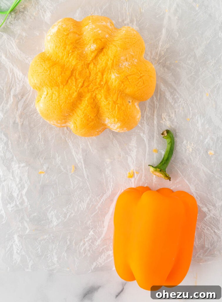 removing a stem from a bell pepper to place on the cheese ball