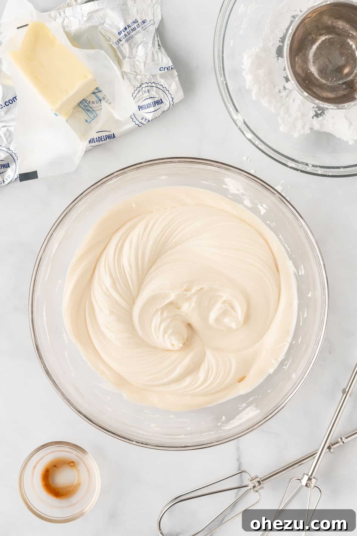 Effortless Fall Spiced Pumpkin Bars 8 A bowl of freshly prepared, smooth and creamy homemade cream cheese frosting, ready to be spread.