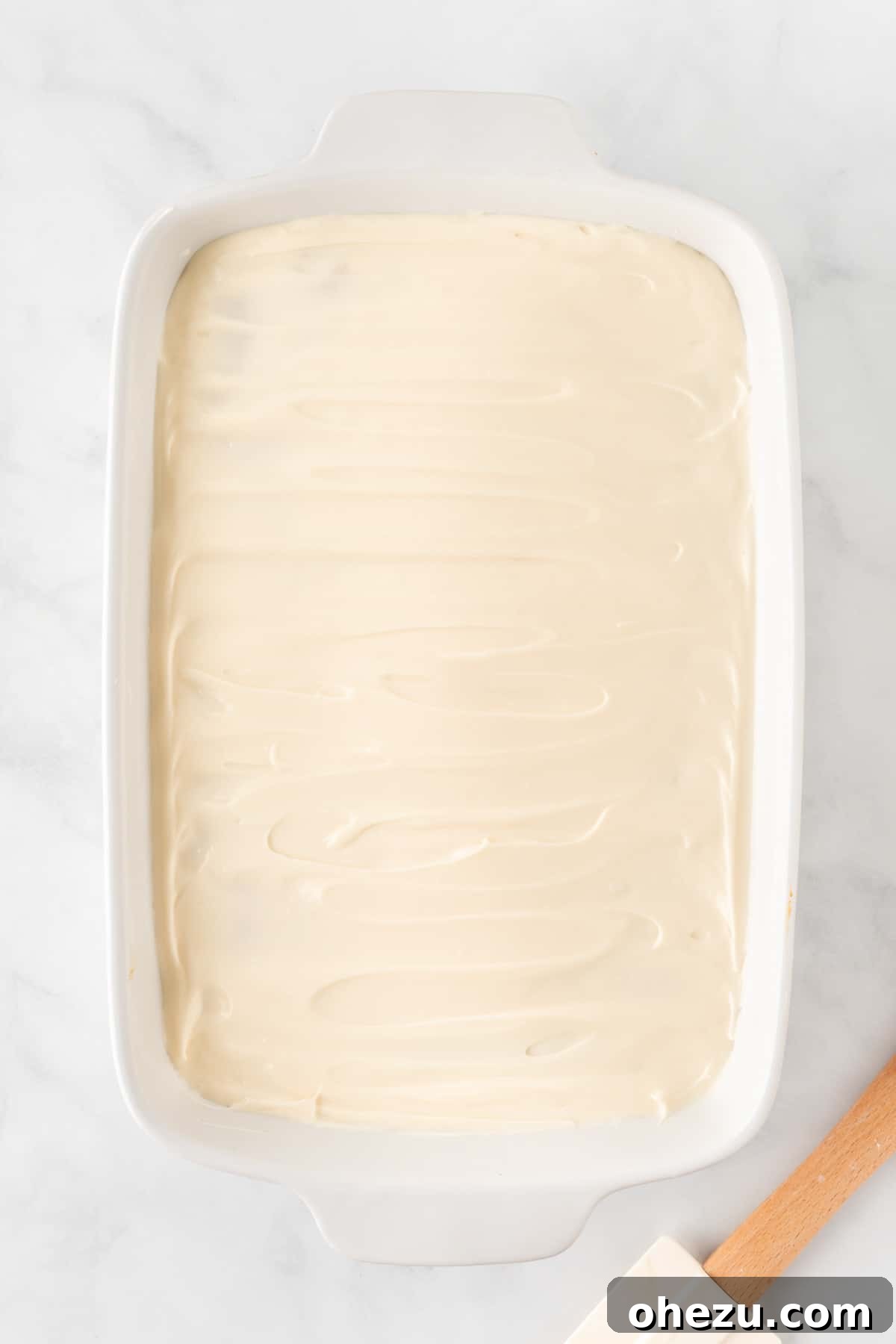 Effortless Fall Spiced Pumpkin Bars 10 A full 9x13 inch baking dish filled with frosted pumpkin bars, featuring a thick, even layer of cream cheese frosting, ready to be cut.