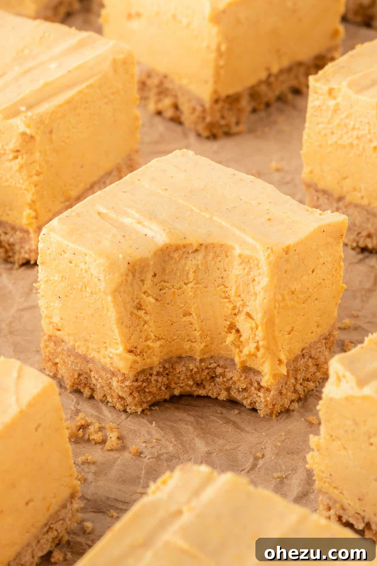 no bake pumpkin cheesecake bar with a bite taken out, showing creamy filling and crust