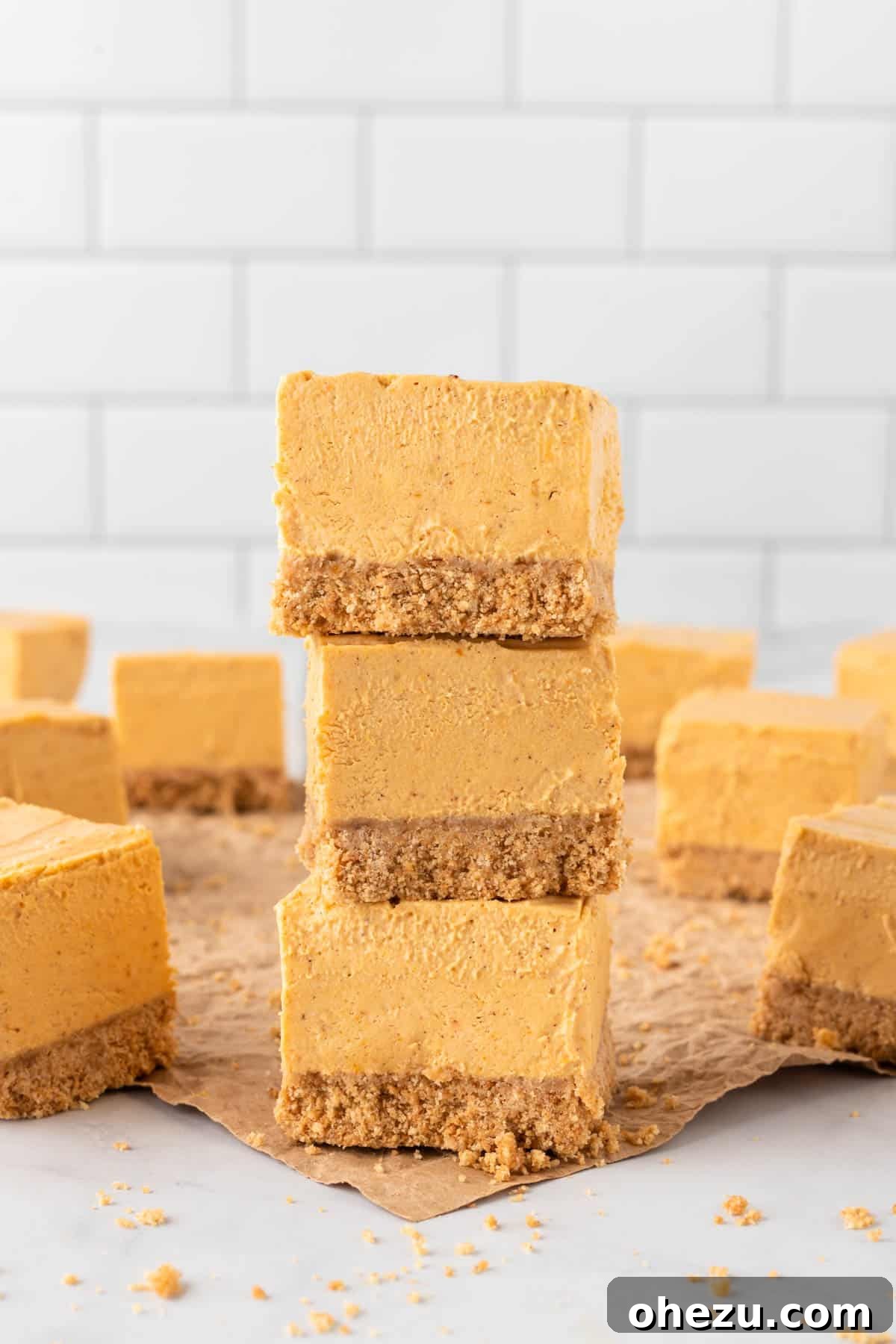 stacked no bake pumpkin cheesecake bars ready to serve on a rustic background