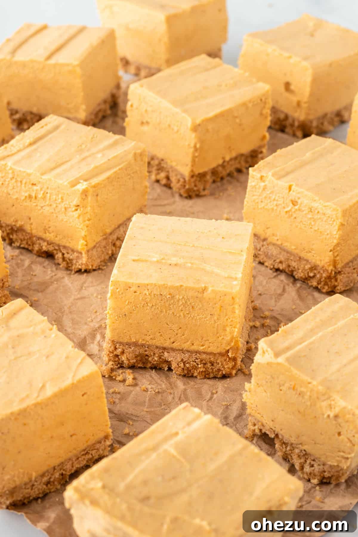 artistic shot of pumpkin cheesecake bars on a rustic wooden surface, garnished with a sprinkle of spice