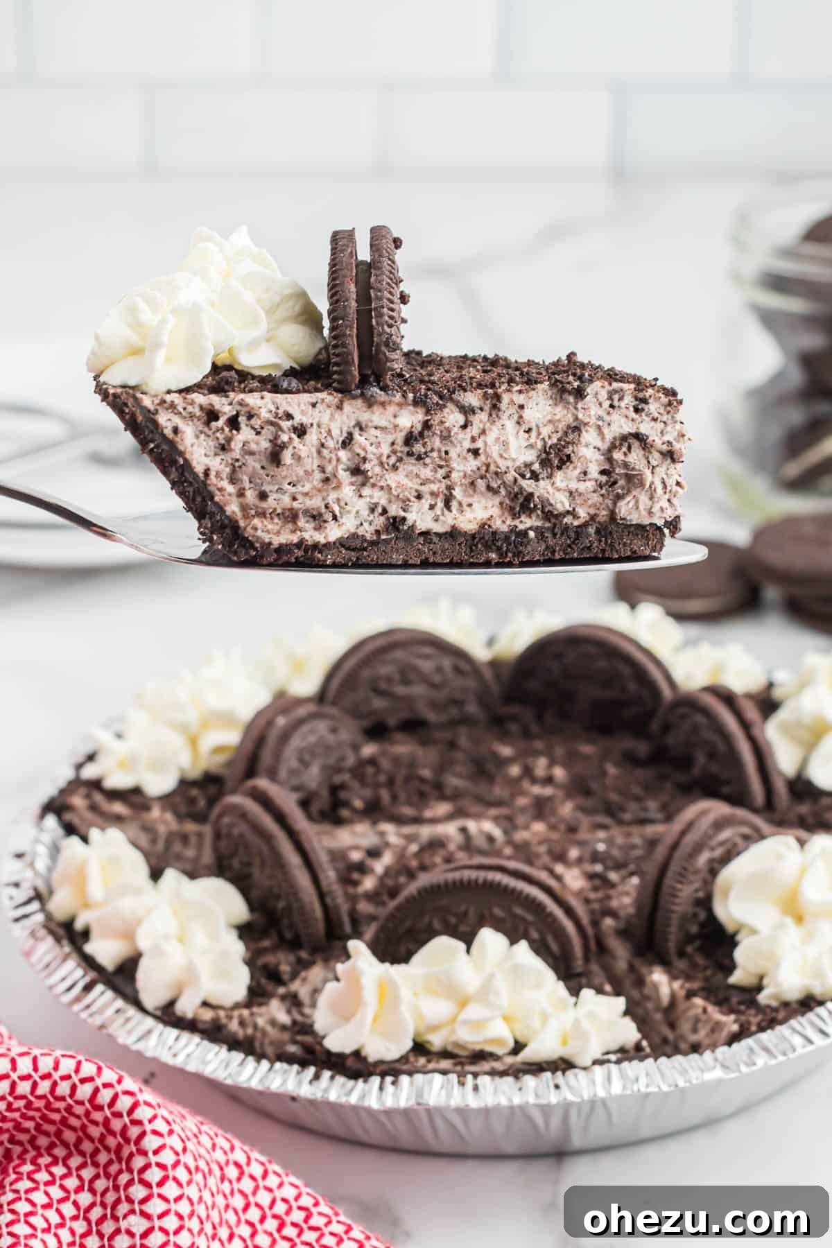 Decadent Oreo Delight 2 A slice of creamy No-Bake Oreo Pie being lifted from the dish, revealing its rich cookies and cream filling and dark chocolate crust.