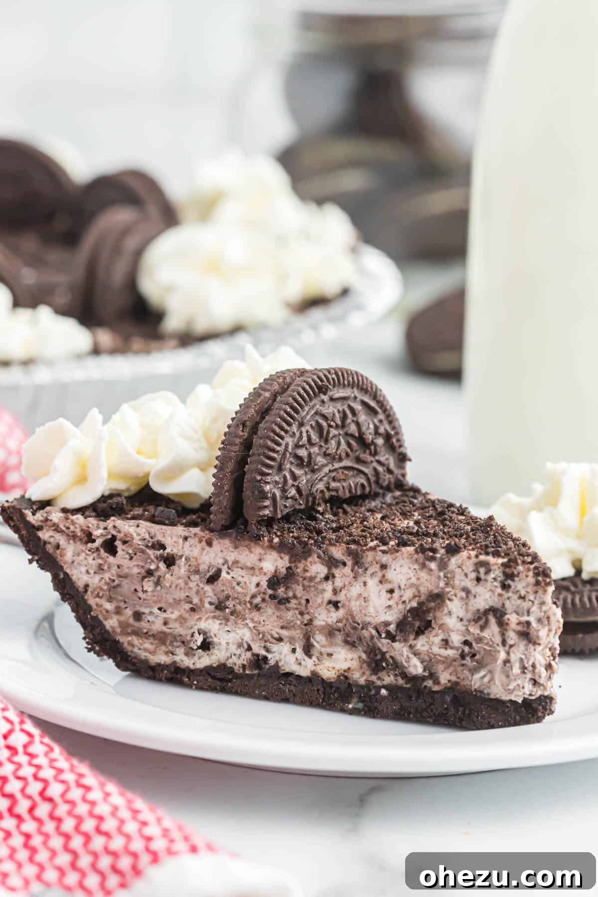 Decadent Oreo Delight 12 A perfect slice of No-Bake Oreo Pie on a white plate, highlighting the distinct layers of crust and filling, ready to be enjoyed.
