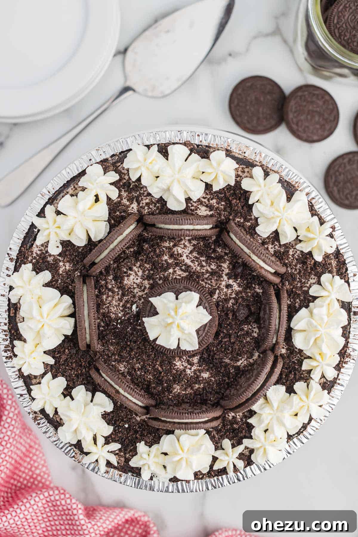 Decadent Oreo Delight 10 A beautifully decorated No-Bake Oreo Pie on a serving plate, adorned with extra whipped cream swirls and whole Oreo cookies for an elegant touch.