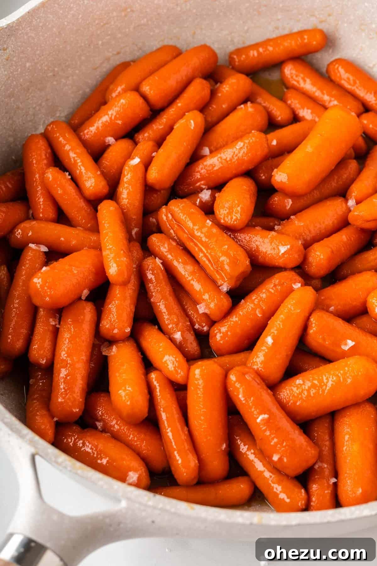 A vibrant close-up of Honey Brown Sugar Glazed Carrots, showing the intricate details of the glaze coating each carrot.